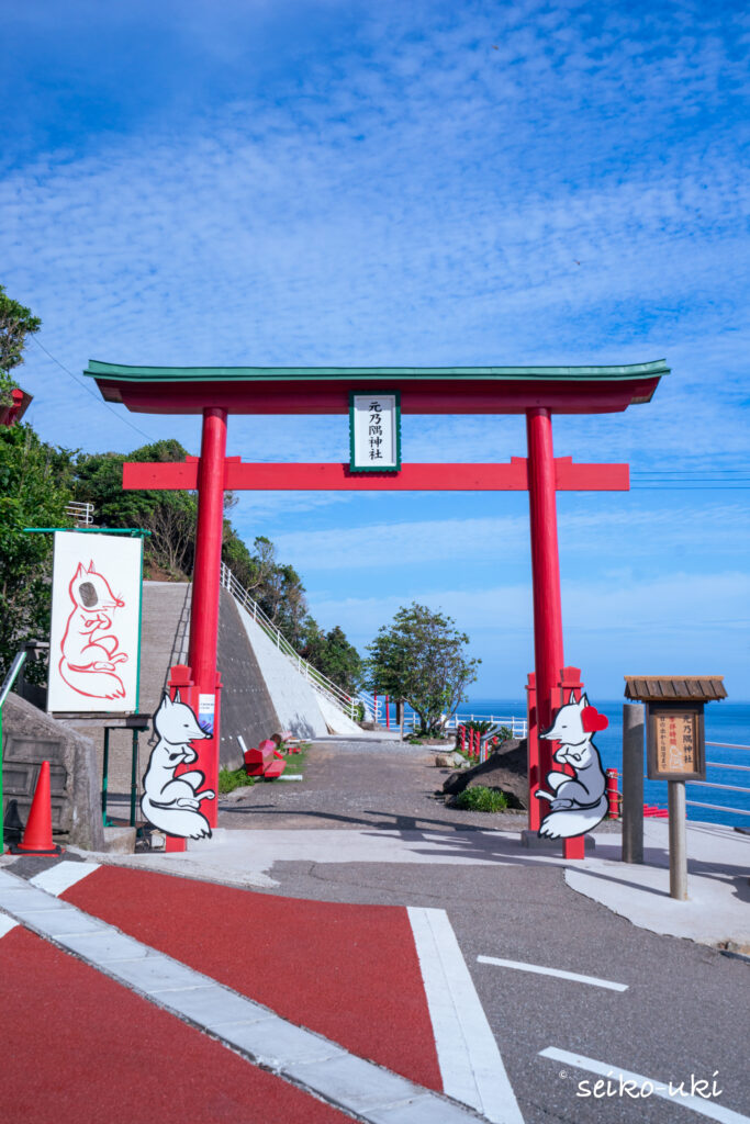 元乃隅神社の入口に立つ大鳥居と白狐が描かれた柱